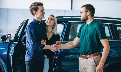 Young couple buying car from dealership