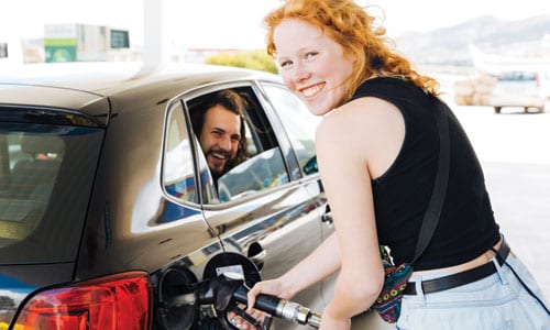 redheaded woman pumping gas