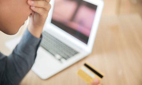 Woman stressed holding credit card